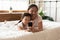 Lying in bed asian mother show daughter cartoons on smartphone