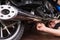 Lying Man Fixing his Motorbike Using Wrench Tool