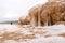 lying pieces of ice on the seashore, icicles of different sizes, textures of sand and ice in the dunes