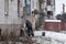 Lyman, Donetsk region, Ukraine - January 2023: A man repairs a chimney from a home-made stove in the basement of a high-rise