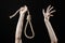 Lynching and suicide theme: man\'s hand holding a loop of rope for hanging on black isolated background