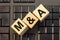 M A - acronym from wooden blocks with letters, concept. M and A - Mergers and Acquisitions