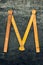 M like measuring. Wooden measure. Old ruler on metal surface. Measuring tool. Technical background