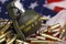 M67 frag grenade and many yellow bullets and cartridges on United States flag. Concept of gun trafficking on USA territory or spec