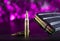 M855 ammo and metal magazine with purple behind