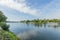 Maas river with a boat anchored on its bank with a vehicular bridge in the background, abundant green vegetation