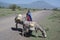 Maasai girl hauling water buckets with her donkey on dirt road in Natron are of Tanzania, Africa