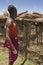 Maasai man and mud house