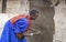 Maasai woman repairing her walls with cow dung