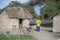 Maasai woman in traditional clothing outside her home