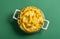 Mac and cheese bowl top view isolated on green background. Cheese macaroni