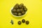 Macadam nuts in a white cup isolated on yellow background.