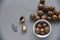 Macadamia nut in a dish with a bottle opener on a gray background. Macadamia nut prepared for use in a vase. Delicious breakfast