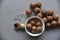 Macadamia nut in a dish with a bottle opener on a gray background. Macadamia nut prepared for use in a vase. Delicious breakfast