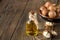 Macadamia oil bottle and macadamia nuts on wooden background