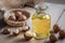 Macadamia oil in bottle and macadamia nuts on wooden table