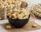 macadamia served in a bowl isolated on napkin side view of nuts on grey background