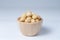 Macadamia in wooden bowl, isolate background