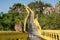 Macaque monkey sitting on the rail of the stairs to Khao Chong Krachok monastery