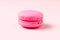 Macaron cookie with filling on pink surface