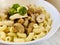 Macaroni, chicken, and button mushrooms in bowl.