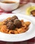 Macaroni dinner with meatballs. Meat pasta served in a white plate over red plaid tablecloth