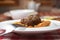 Macaroni dinner with meatballs. Meat pasta served in a white plate over red plaid tablecloth