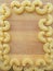 Macaroni pasta frame on wooden background