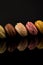 Macarons, Colorful Horizontal Stack of Macarons, isolated on black background with reflections, copy space, multiple colors,