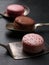 Macarons are on the cutlery, black background. Closeup