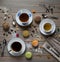 Macarons multicolored, cups with black and green tea and with coffee, vintage spoons, fork and knife on a wooden table with variou