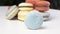 Macarons from natural ingredients, blue macaron rolling on a white table.