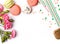 Macarons, paper straws, flowers and confetti on the white background