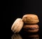 Macarons Pile, Beautiful Brown Chocolate Stack of Macarons, isolated on black background with reflections, copy space
