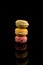 Macarons Pile, Colorful Stack of Macarons, isolated on black background with reflections, copy space