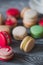 Macarons on rustic wood table, French candy meringue-based made with egg white, icing sugar, granulated sugar, almond