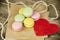 Macarons in various colors on paper near red paper heart