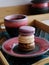 Macaroons on pottery craft ceramic clay plate. Cup of coffee. Wooden tray. Handmade ware aesthetics