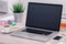 Macbook laptop mockup on office desk with smartphone and cup of coffee