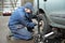 Machanic repairman at tyre fitting with car jack