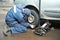 Machanic repairman at tyre fitting with car jack