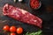 Machete steak raw alternative beef cut or hanging tende cut, with rosemary over wood background Top side view