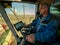 The machine operator at the helm of a modern combine harvester harvests grain