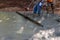 Machine to align fresh concrete compacts a layer of fresh concrete a new driveway construction