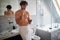 Macho topless man texting while brushing teeth