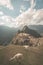 Machu Picchu illuminated by the last sunlight coming out from the opening clouds. Wide angle view from above with two grazing llam