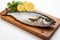 Mackerel on cutting board isolated against a white backdrop, capturing freshness.