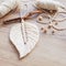 Macrame leaf  in natural color and thread windings lying on a wooden table. Cotton rope decor macrame to make your room more cozy