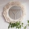 Macrame mirror on a white wall.  The mirror reflects macrame wallhanging. Eco-style. Natural materials. Soft fokus