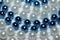 Macro abstract art texture of blue and white reflective beads in a circular pattern